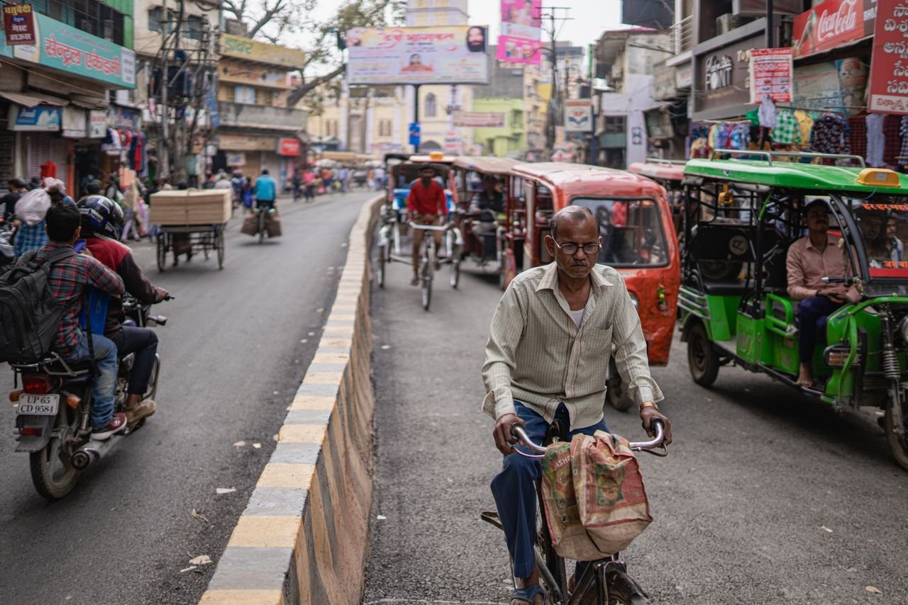 Mastering the First Impression: Your intriguing post title goes here Lively street in Varanasi featuring bicycles, tuk-tuks, and vibrant local culture.