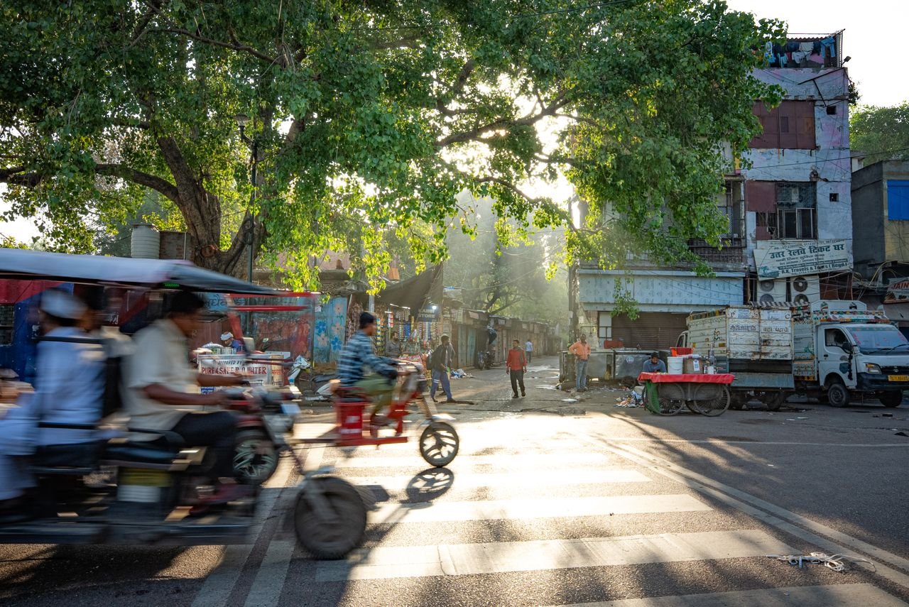 Services Vibrant morning hustle on Delhi streets capturing e-rickshaws and pedestrians in motion.